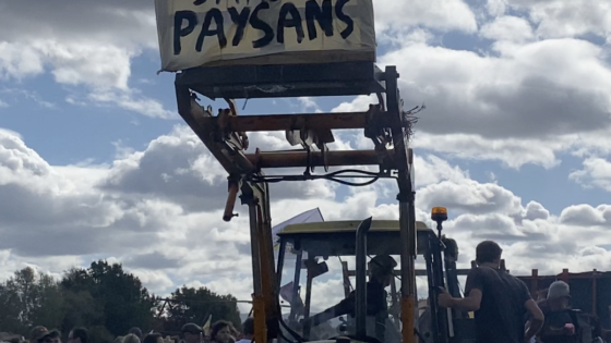Un tracteur dans une manifestation avec une pancarte "Pas de pays sans paysans"